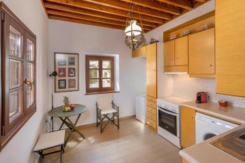 a kitchen with a table and a small table with chairs at Filigrana Villa Lindos in Lindos