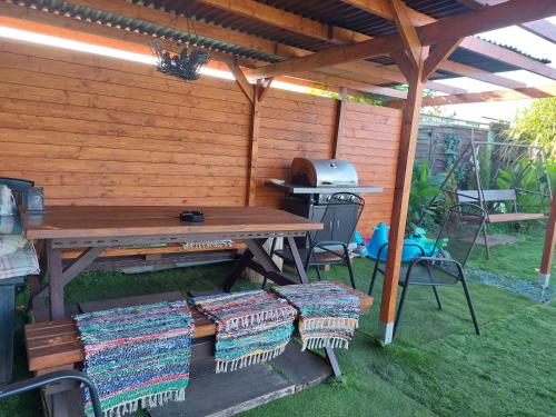 a picnic table and chairs under a wooden pergola at Penzion U Ježů - Ubytování in Pasohlávky