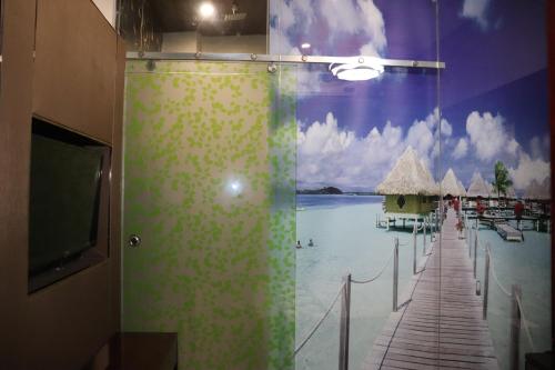 a bathroom with a shower with a painting of a beach at Hotel Shivam Palace 1 Km from Railway Station 1 Km from Bus Stand in Ajmer