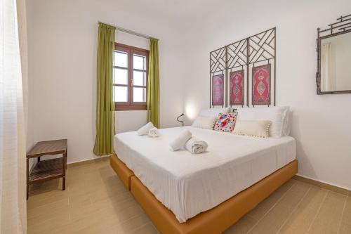 a bedroom with a large white bed in a room at Filigrana Villa Lindos in Lindos