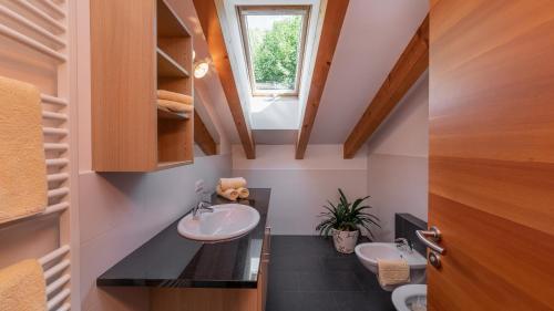 een badkamer met 2 wastafels en een raam bij Haus Alpenjuval in Fundres