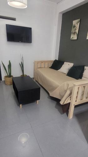 a bedroom with a bed and a tv on the wall at Duplex Donovan in Resistencia