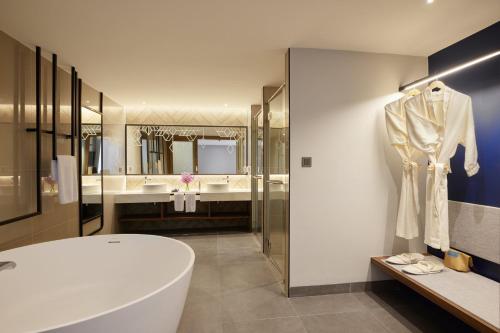 a bathroom with a white tub and two sinks at Centara Life Hotel Bangkok Phra Nakhon in Bangkok