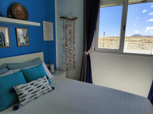 um quarto com uma cama e vista para a praia em CorralejoDunas piscinas wifi tenis bicicletas em Corralejo