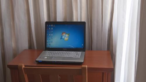 
a laptop computer sitting on top of a wooden desk at Triton Hotel Piraeus in Piraeus

