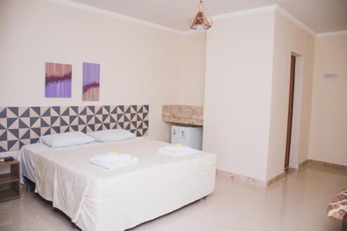 um quarto branco com uma cama branca num quarto em CALDAS PALACE HOTEL JORRO em Tucano