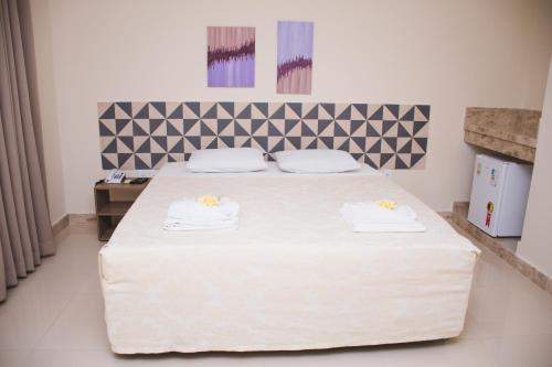 um quarto com uma cama grande com duas toalhas em CALDAS PALACE HOTEL JORRO em Tucano