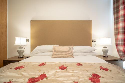 a bedroom with a large bed with two lamps at Redcliffe Hotel in Inverness