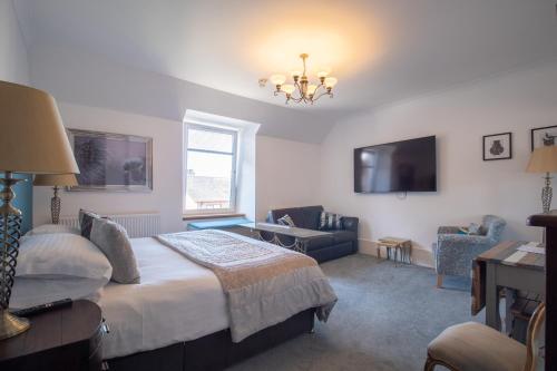 a bedroom with a bed and a living room at Redcliffe Hotel in Inverness