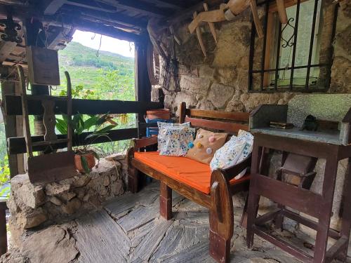 un banc en bois installé dans une pièce avec fenêtre dans l'établissement Casas Rurales El Cerro y El Cerezo, à Navaconcejo