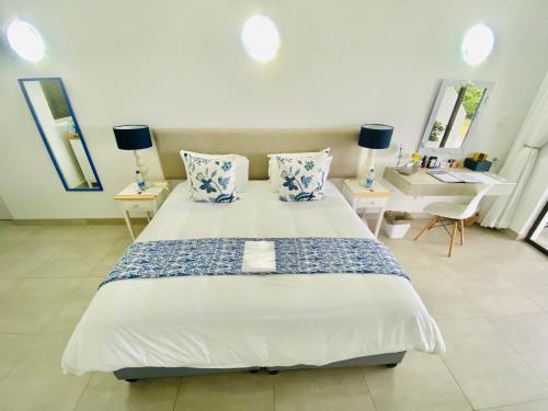a bedroom with a large bed with blue and white pillows at My-konos in St Francis Bay