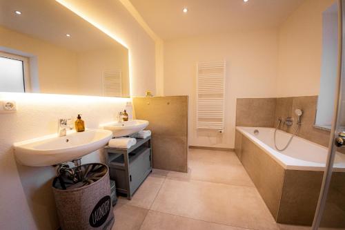 a bathroom with two sinks and a bath tub at Servus Apartments Premium in Vilshofen an der Donau