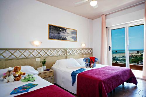 una camera d'albergo con due letti con animali di peluche di Hotel Doge ad Alba Adriatica