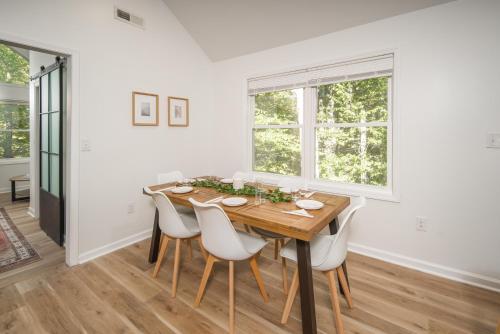 布恩的住宿－The Wanderer Guesthouse，一间带木桌和白色椅子的用餐室