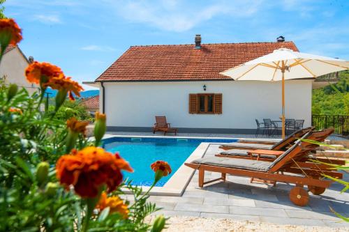 a villa with a pool and a patio with chairs and an umbrella at Holiday House Tone, Imotski-Drum-Makarska in Drum