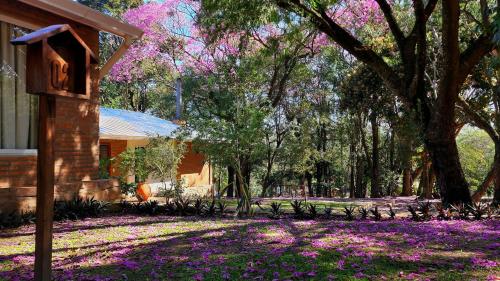 a house with purple flowers in the yard at Vista Alegre Natural Resort - Villas & Cabañas in Independencia