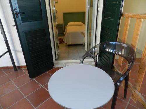 a white table and a chair in front of a door at Hotel Il Mulino in Capo dʼOrlando