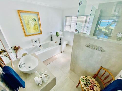 La salle de bains est pourvue d'un lavabo, d'une douche et d'une baignoire. dans l'établissement My-konos, à St Francis Bay