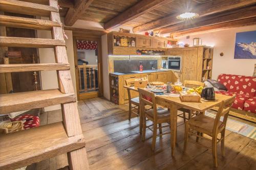 a kitchen with a table and chairs in a room at Baita Relais La Cesarina in Vico Canavese