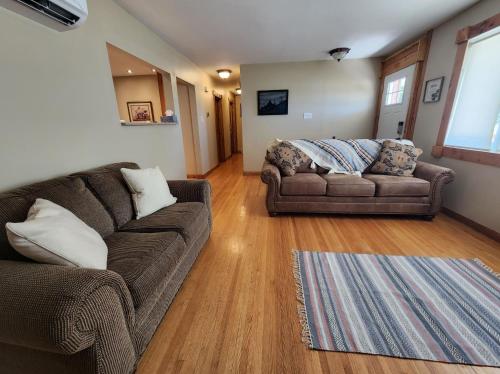 a living room with two couches and a rug at Feel at home, Country style family house. in Magrath