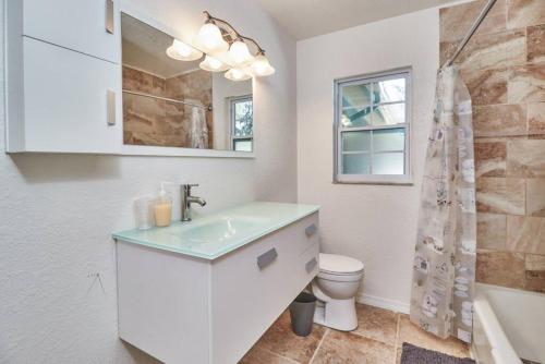 a white bathroom with a sink and a toilet at Large Groups Up to 12 Guests In ground POOL in Tampa