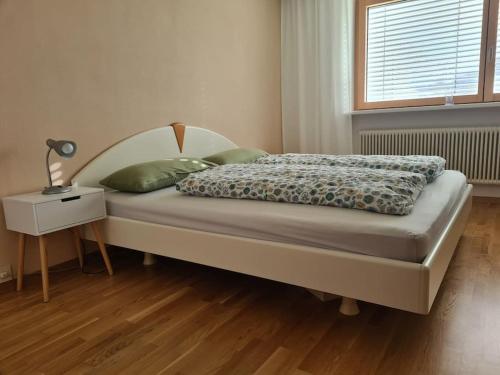 a bedroom with a bed and a night stand and a window at Haus Renate in Wolfurt