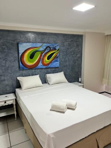 1 dormitorio con 1 cama grande y una pintura en la pared en Residence Iracema Porto, en Fortaleza