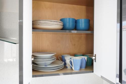 a cupboard filled with plates and bowls and dishes at Milan San Marino in Tijuana