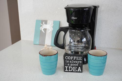 a coffee maker and two cups on a counter at Milan San Marino in Tijuana