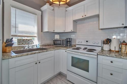 a kitchen with white cabinets and a stove top oven at Gorgeous Loft Apartment Centrally Located Tampa in Tampa