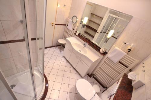 a bathroom with a toilet and a sink and a shower at Hotel Strandidyll in Grömitz