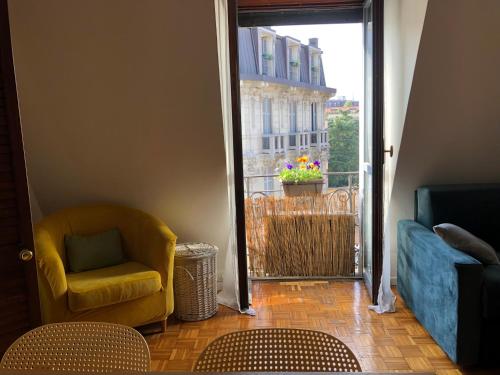 een woonkamer met een stoel en een raam bij Easy Isola, for an easy stay in Milaan