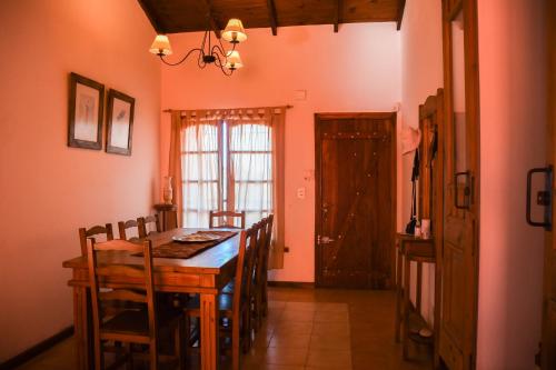 een eetkamer met een houten tafel en stoelen bij Casa Bordó, B & B in Tandil