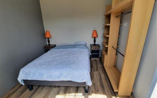 une chambre avec un lit et deux tables de nuit avec lampes dans l'établissement Jolie maison de campagne à 2km de la mer, à Plomodiern