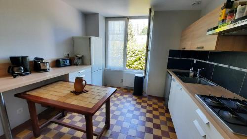 une petite cuisine avec une table et un évier dans l'établissement Jolie maison de campagne à 2km de la mer, à Plomodiern