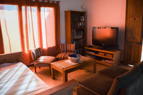 a living room with a couch and a tv at Casa Bordó, B & B in Tandil