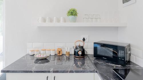 a kitchen with a counter top with a microwave at 34.4 Degrees South Studio Apartment in Agulhas