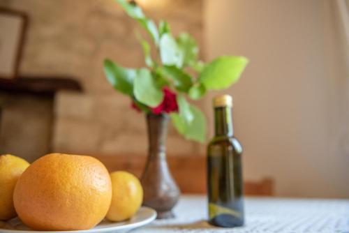 a table with a bottle of wine and a vase with flowers at Andros traditions house in Kathikas