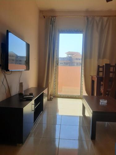 a living room with a television and a large window at Chalets in Porto Sharm in Sharm El Sheikh
