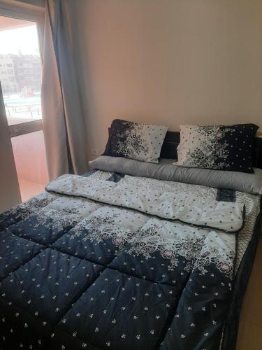 1 cama con edredón azul y almohadas en un dormitorio en Chalets in Porto Sharm en Sharm El Sheikh