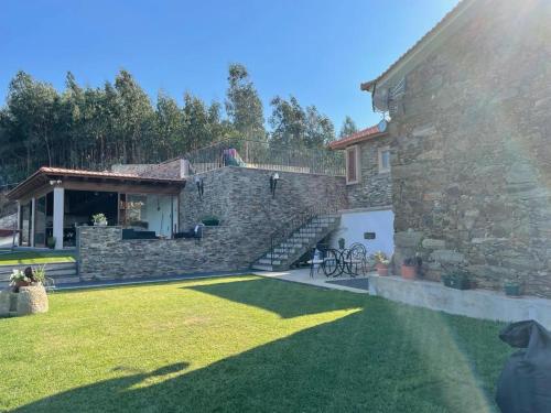 a stone house with a lawn in front of it at Refúgio in Castelo de Paiva