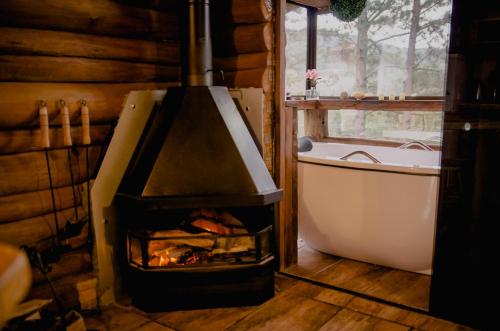 y baño con chimenea y bañera. en Refúgio do Caracol Pipas e Chalés, en Canela