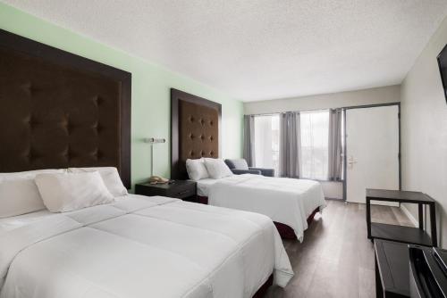 ブライズビルにあるAmericas Best Value Inn and Suites Blytheville by Sonestaのベッドが2つと窓があるホテルの部屋