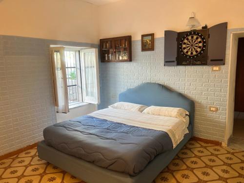 een bed in een kamer met een klok aan de muur bij la casina rossa B&B "Da capachiatta" in San Sebastiano al Vesuvio