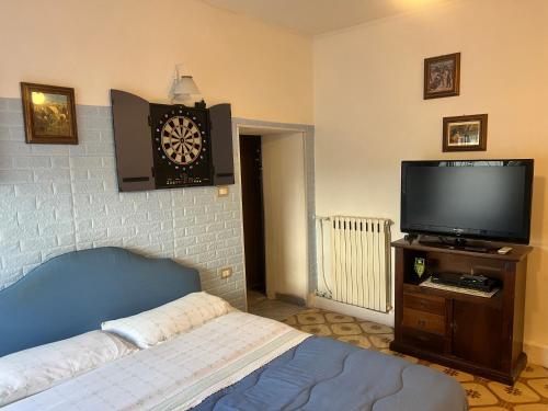 een slaapkamer met een bed en een tv en een klok bij la casina rossa B&B "Da capachiatta" in San Sebastiano al Vesuvio
