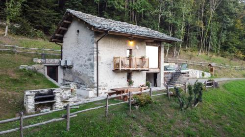a small house with a porch and a balcony at Baita Relais La Cesarina in Vico Canavese