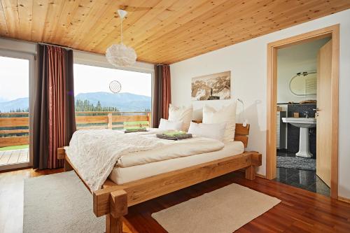 a bedroom with a bed and a large window at Elchegg - Chalet & Panorama-Loft in Rettenberg