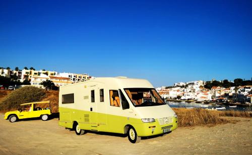 una furgoneta blanca y amarilla estacionada en un estacionamiento en Rent a BlueClassics 's Campervan AUTOSTAR in Algarve au Portugal, en Portimão