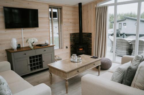 a living room with a fireplace and a tv at Casa Di Lusso Luxury lodge in Woodhall Spa