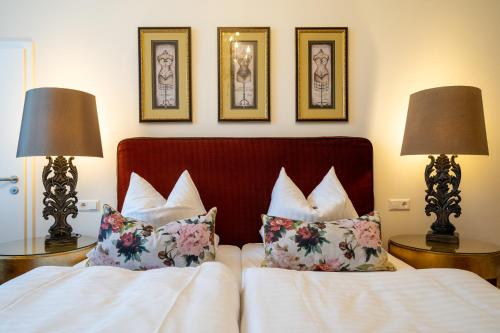 a bedroom with a bed with pillows and two lamps at Hotel Villa am Stadthafen in Neustrelitz